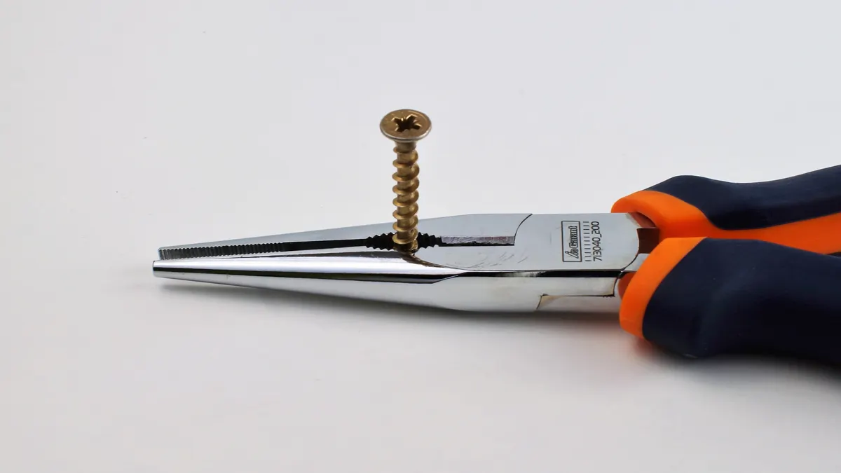 Pliers gripping a screw
