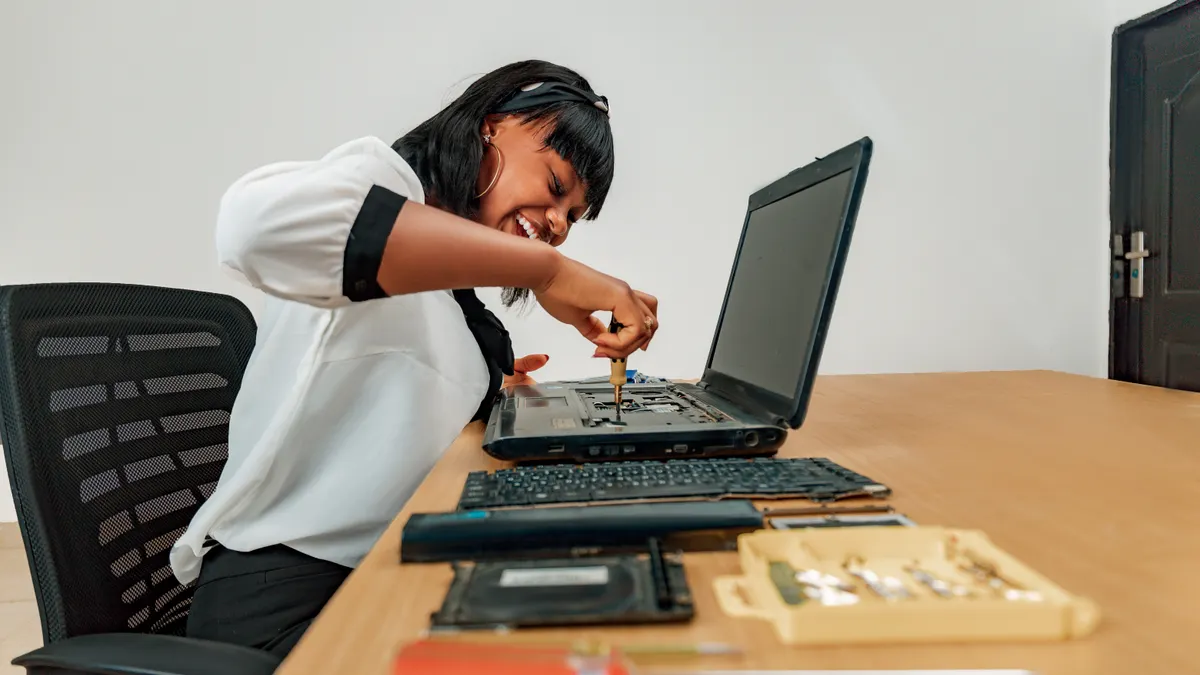 Laptop screwdriver sizes and bit types explained Person repairing an open laptop on a desk